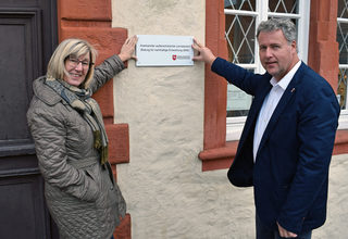 Museumspädagogin Christine Kellner-Depner und Kulturdezernent Jan Erik Bohling mit der Tafel, die am Städtischen Museum auf den Außerschulischen Lernort hinweisen wird.