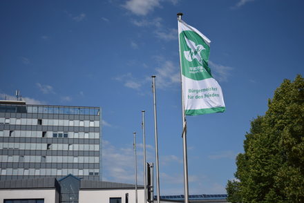 Flagge "Bürgermeister für den Frieden" weht vor dem Rathaus.