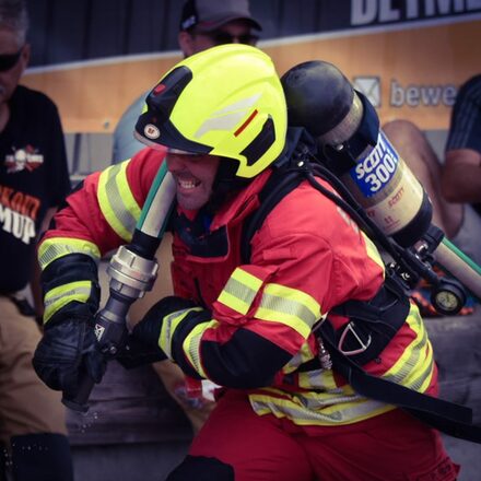 Feuerwehrmann zieht einen Schlauch.