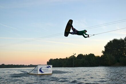 Wassersportler an der Wasserskianlage.