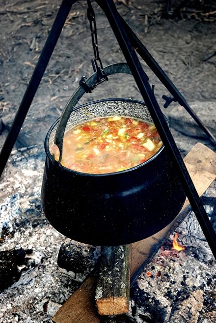 Die Teilnehmenden bereiten sich ihr Essen am Lagerfeuer zu.