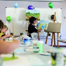 Regina Smuda zeigte den Kindern, wie man mit feinen Pinselstrichen auf der Leinwand eine Landschaft kreiert.